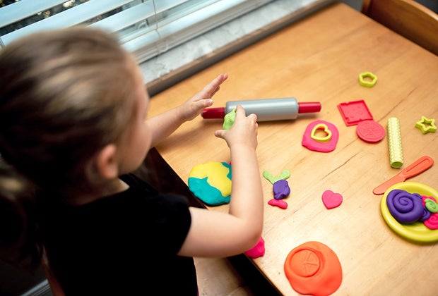 Girl playing with playdough to combat boredom.