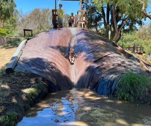 Slide into muddy fun at Adventure Playground! 