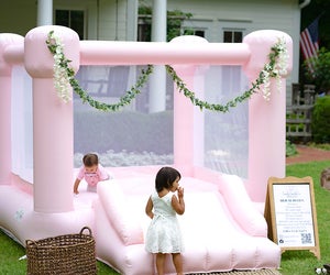 Add a charming bounce house, like this one from Candy Castle Co., to enhance your child's next birthday party. Photo by Wilson Creative Co. Photography, courtesy of Candy Castle Co.